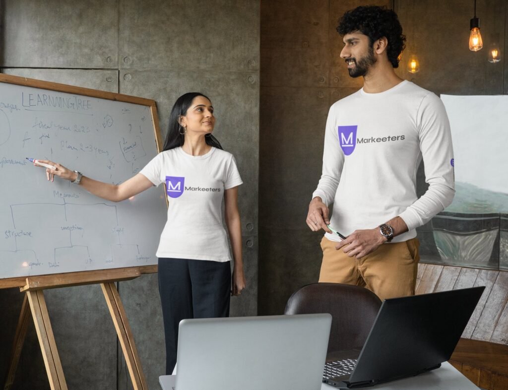 t-shirt-mockup-featuring-a-man-and-a-woman-using-a-whiteboard-at-an-office